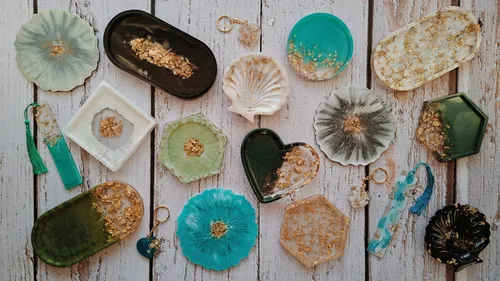 Resin crafts with gold accents on wood background.