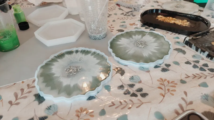 Decorative resin coasters on floral tablecloth.