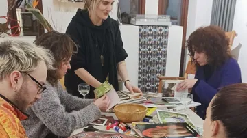 Gruppe bastelt an Tisch drinnen.