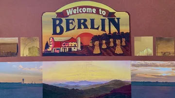 Berlin welcome sign with scenic landscapes.
