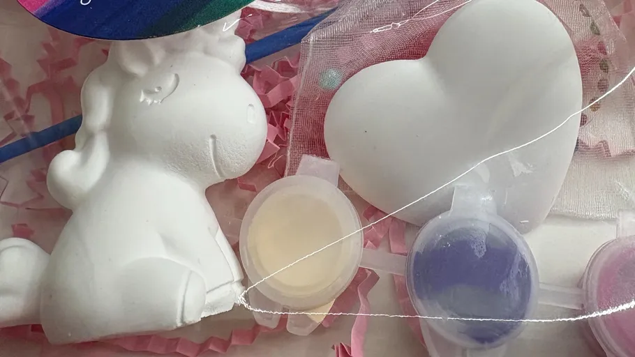 Unicorn figurine with paints and heart shape.