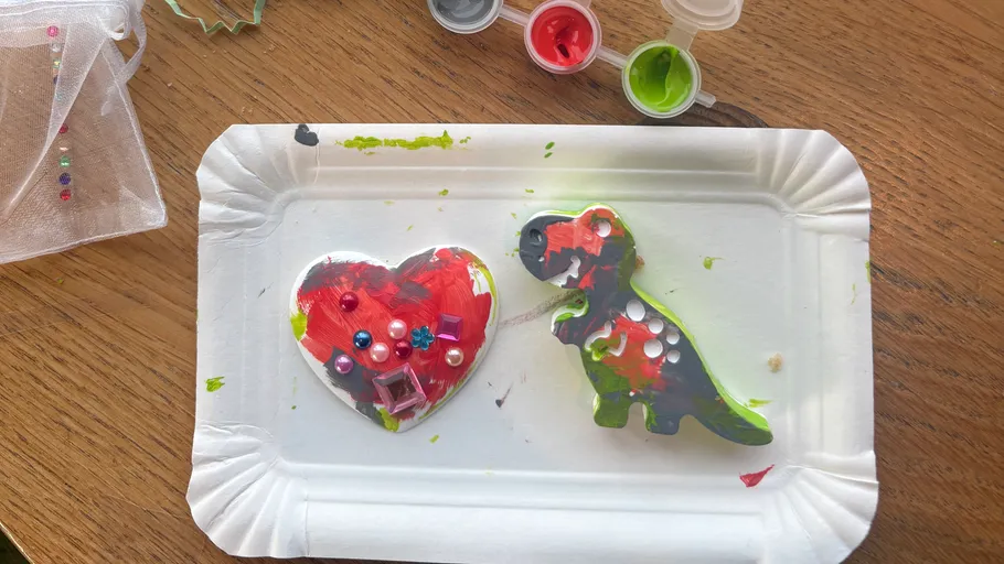 Bemaltes Herz und Dinosaurier auf Tablett.