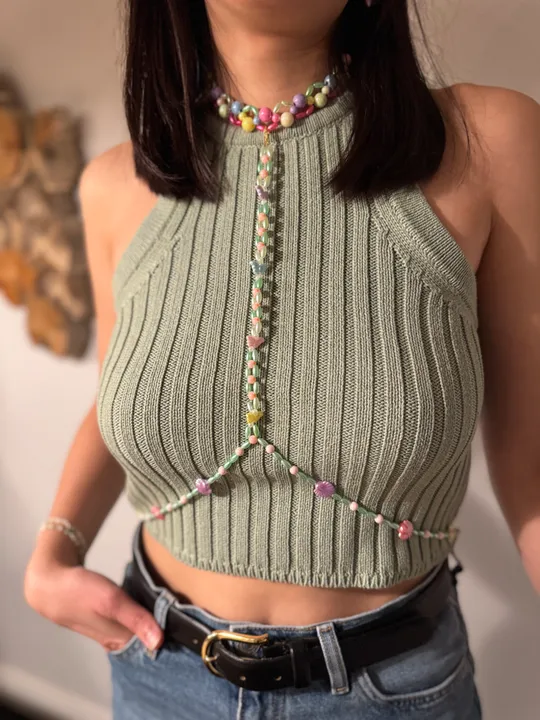 Frau trägt gestricktes Top mit Perlenkette.