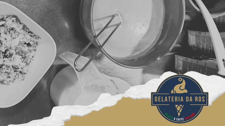 Bowl with mixture and whisk on metal table.