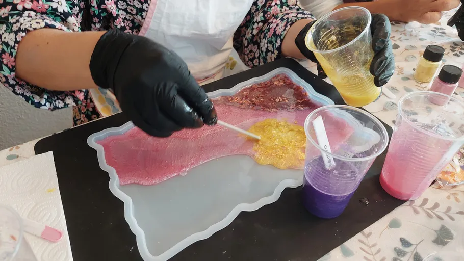 Person pouring resin into Spain-shaped mold.