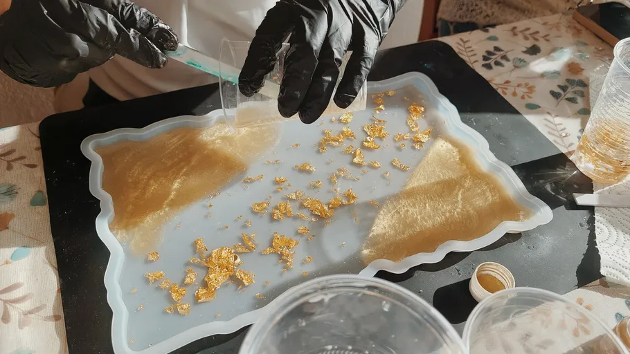 Person pouring resin into a mold.