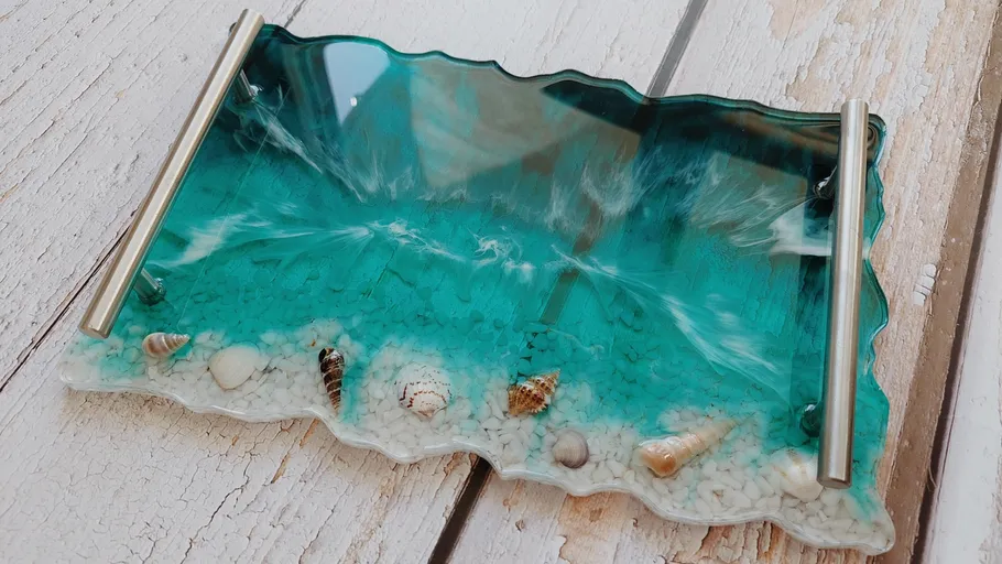 Harztablett mit Meereswellen und Muscheln.