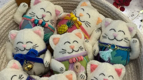 Stuffed cats with accessories in a basket.