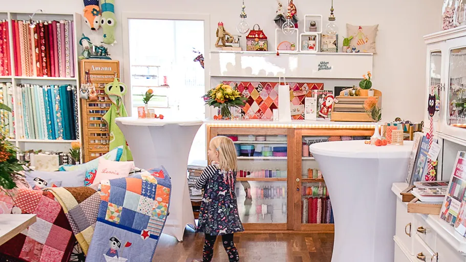 Child exploring a colorful fabric store.