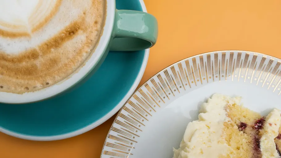 Coffee and cake on a colorful table.