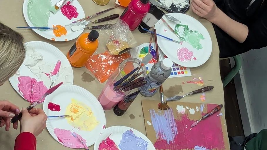 People mixing paint on paper plates.