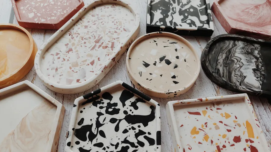 Bunte Terrazzo-Tabletts auf Holzoberfläche.