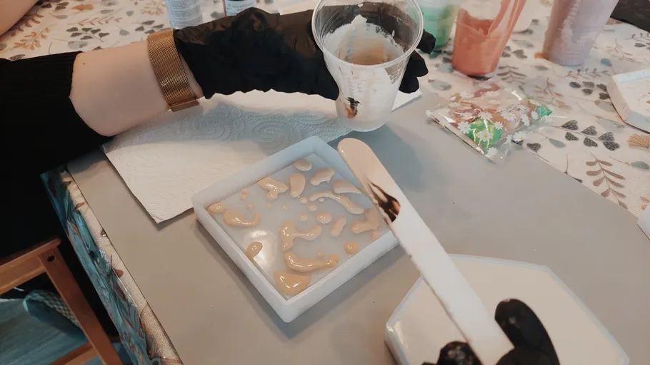Person pouring resin into silicone mold.