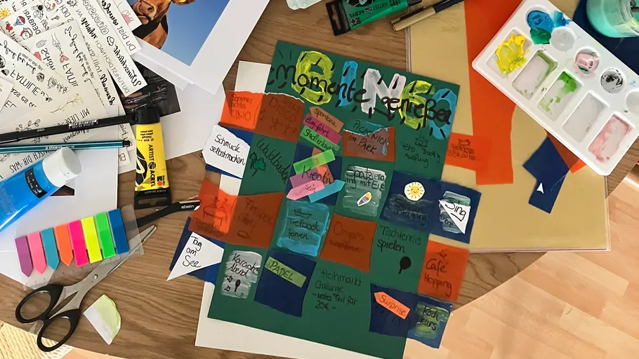 Bunte Kunstmaterialien auf einem Holztisch angeordnet.