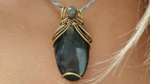 Pendant with stone and wire design on neck.
