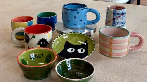Colorful mugs and bowls on a table.