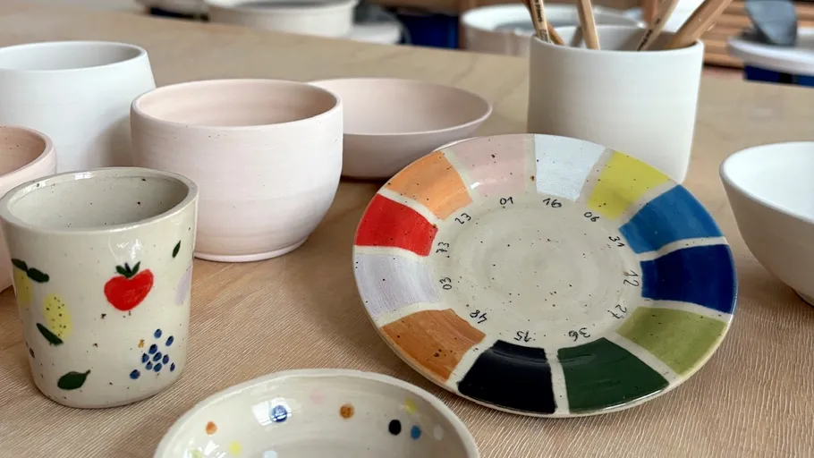 Colorful ceramic dishes on wooden table.