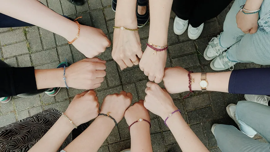 Hände mit Armbändern im Kreis, Outdoor-Pflaster.