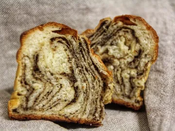 A piece of bread with marbled filling lies on a towel.