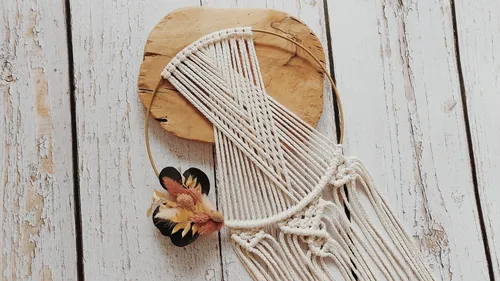 Macrame wall hanging on rustic wooden surface.