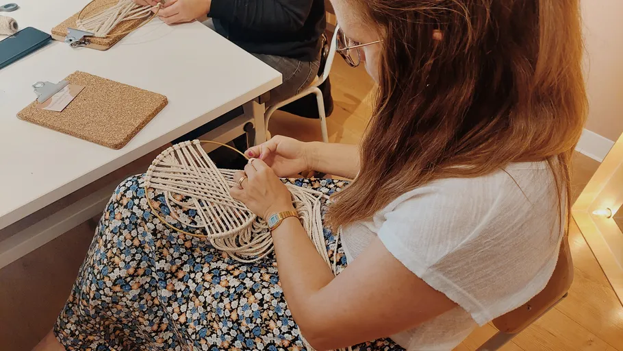 Woman doing macramé in a cozy room.
