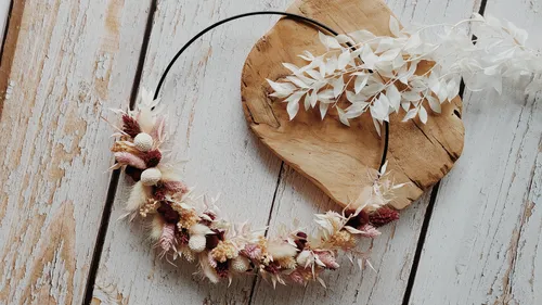 Floral wreath on rustic wooden background.