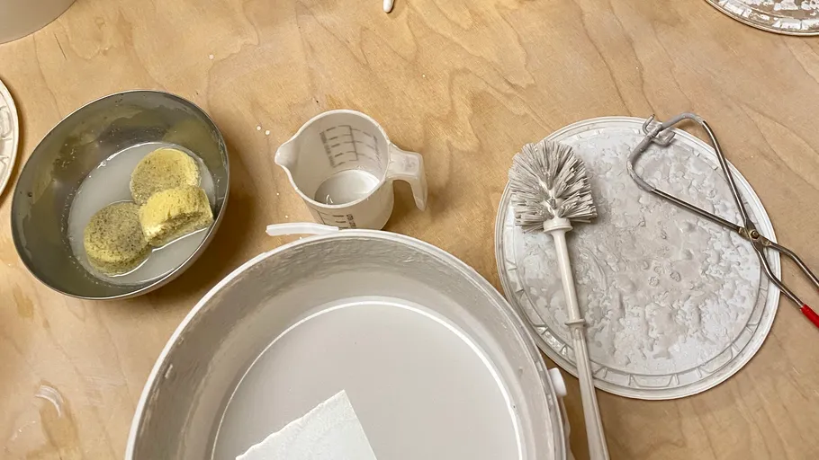 Cleaning tools and sponges on a wooden table.