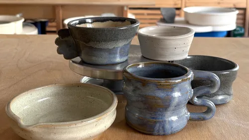 Handmade pottery cups on a wooden table.