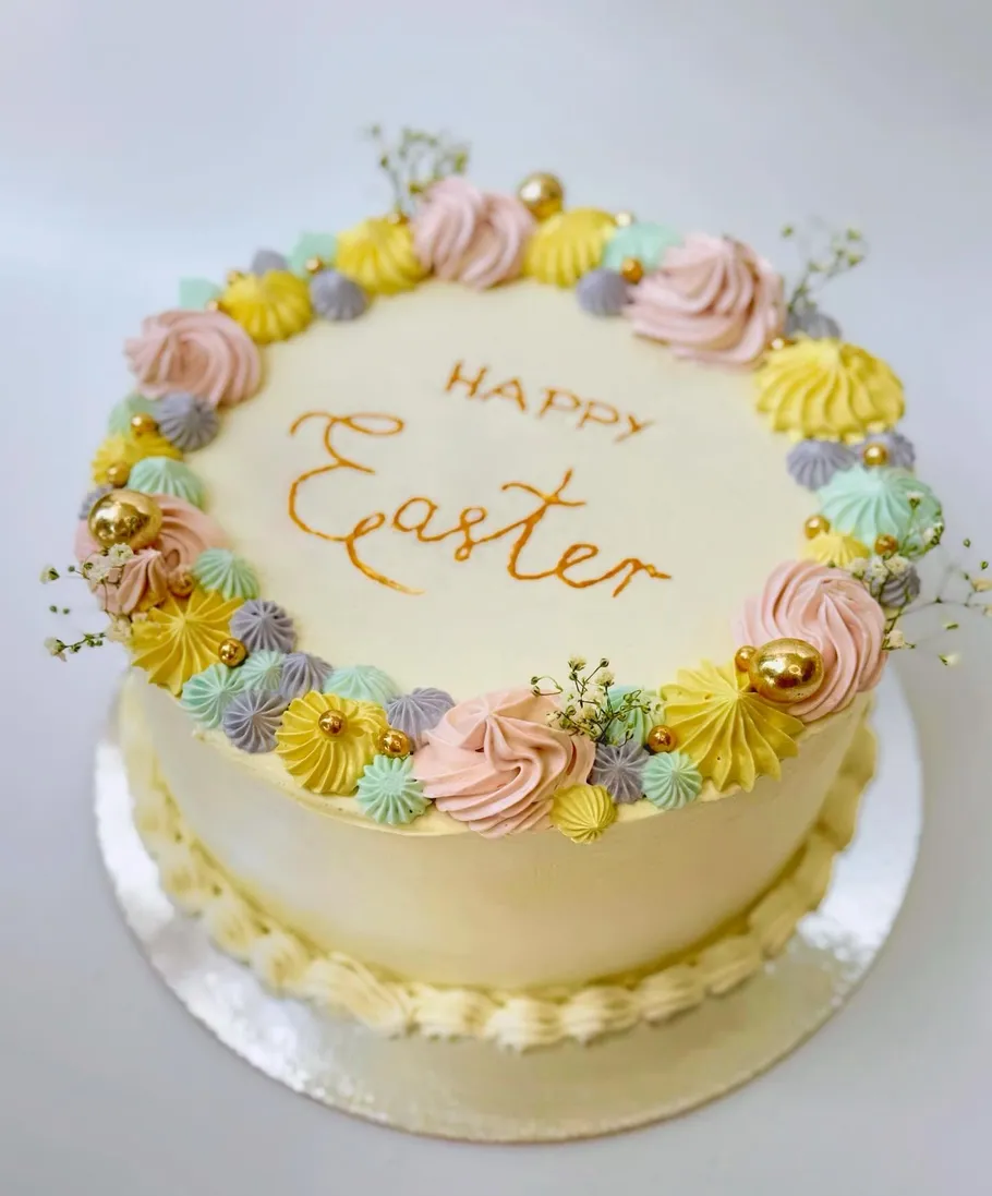 Osterkuchen mit pastellfarbenen Dekorationen und Blumen.