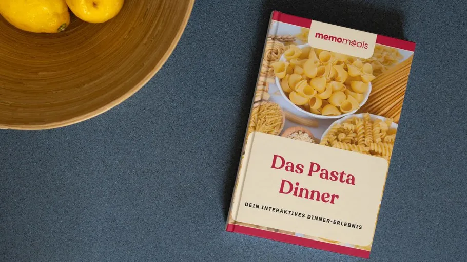 Pasta-Kochbuch neben Zitronen in Schale.