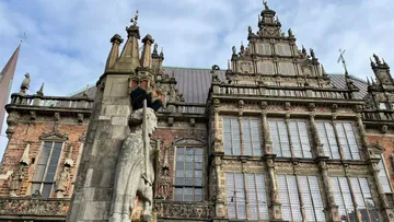 Statue vor kunstvollem historischem Gebäude.