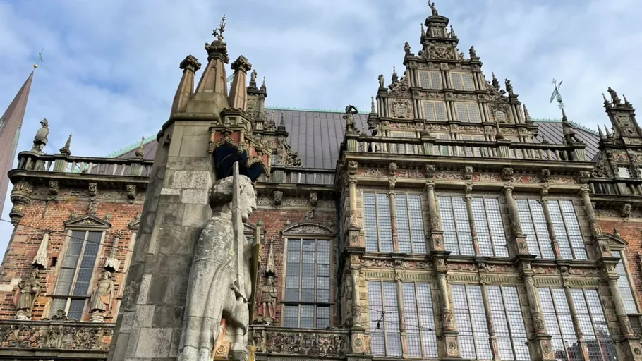 Statue in front of ornate historic building.