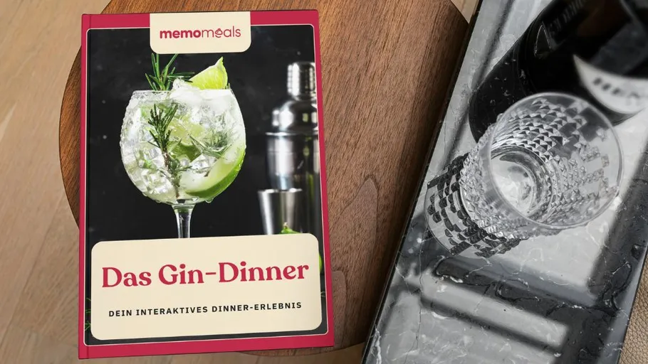 Cocktail book and glasses on wooden table.