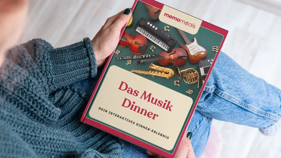 Person hält Buch mit 'Das Musik Dinner'.