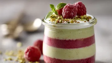 Layered dessert with raspberries in a jar.