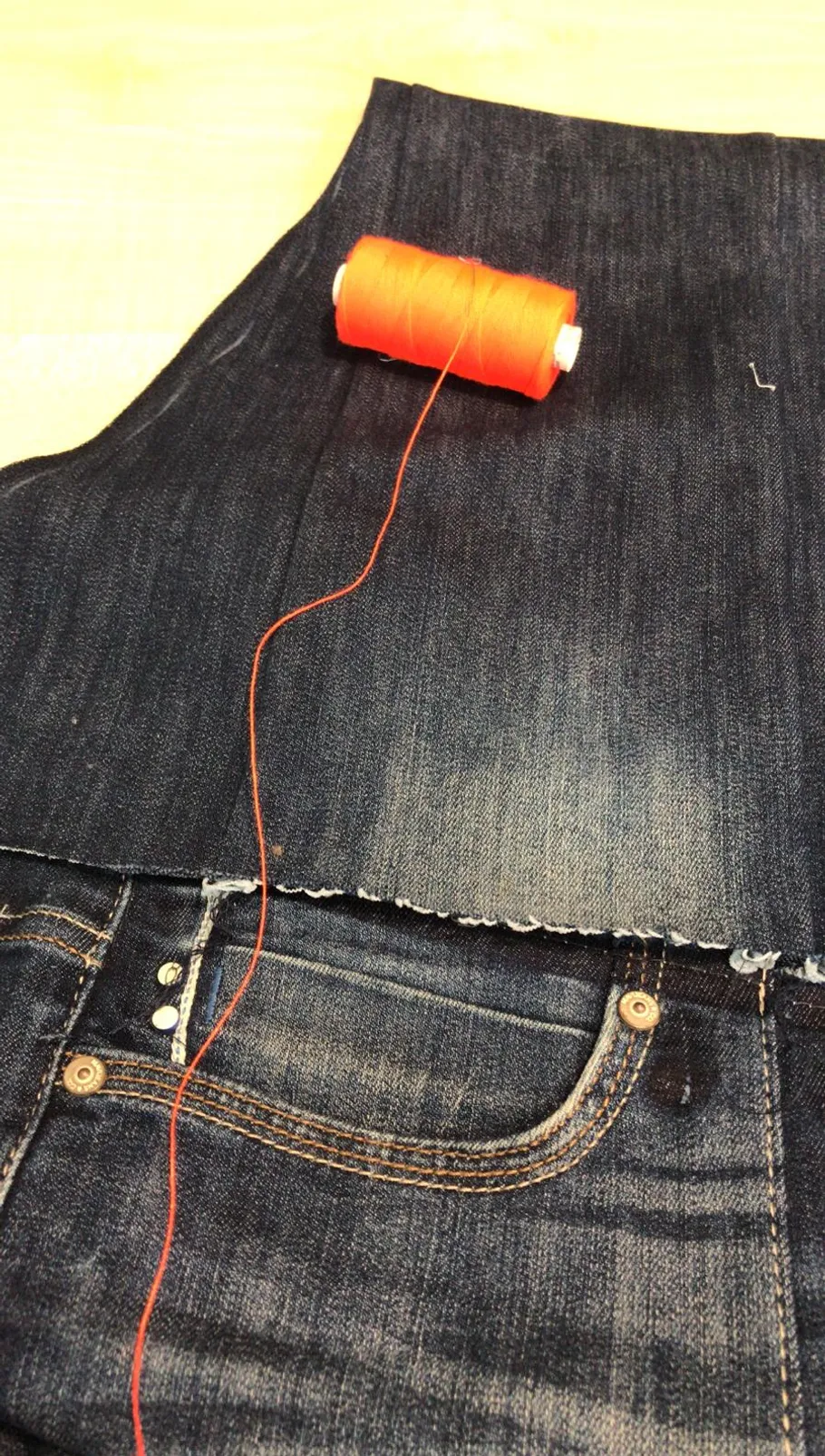 Orange thread on denim fabric with jeans.