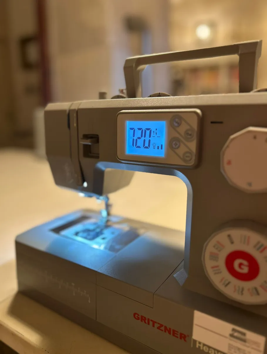 Nähmaschine mit beleuchtetem Digitaldisplay.