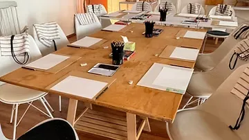 Holztisch mit Stühlen in Besprechungsraum.