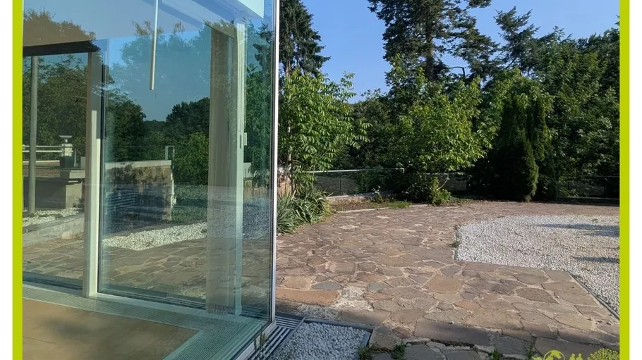Glass door leading to stone patio, garden visible.