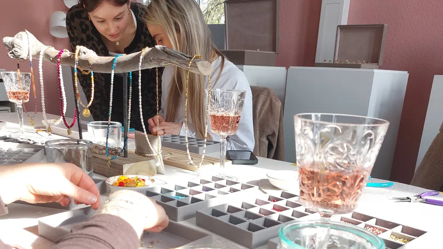 Two women crafting jewelry indoors.