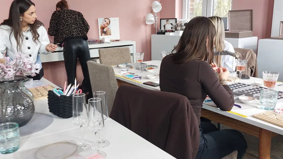 Frauen fertigen Schmuck in einem Workshop-Raum an.