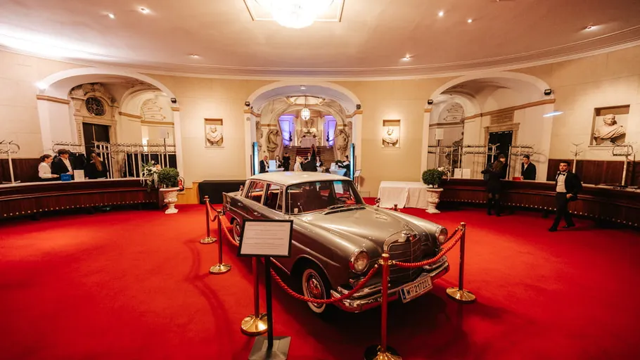 Classic car displayed in elegant lobby.