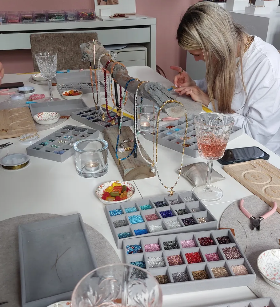 Frau erstellt Schmuck in einem Perlen-Workshop.
