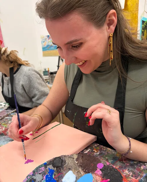 Frau malt auf Leinwand im Kunststudio.