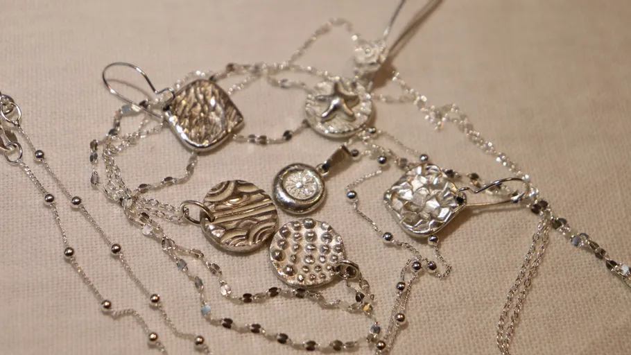 Silver necklaces with various textured pendants.