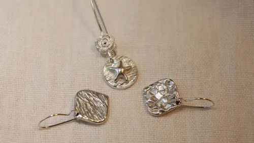 Silver starfish necklace and two textured earrings.