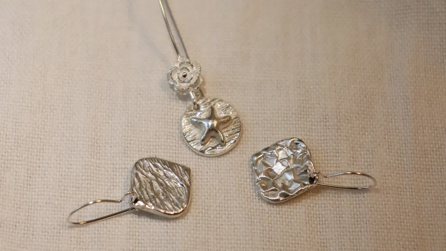 Silver starfish necklace and two textured earrings.