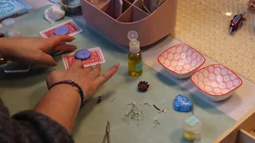 Hands crafting soap on a tabletop.