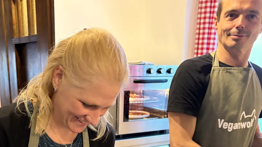 Two people cooking together in kitchen.