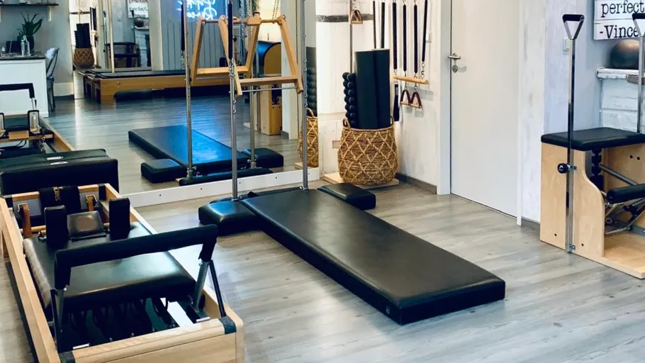 Empty Pilates studio with reformer machines.